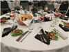 Pre-set tables with place settings and salads and rolls and parfaits in wine glasses