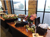Wedding reception Buffett tables with food and flowers in front of windows