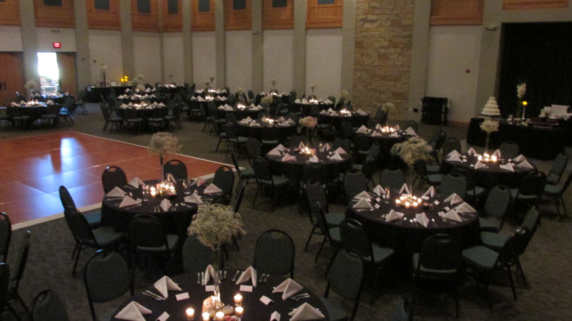 Elegant black and white wedding reception of pre set tables with black table cloths accented with wh